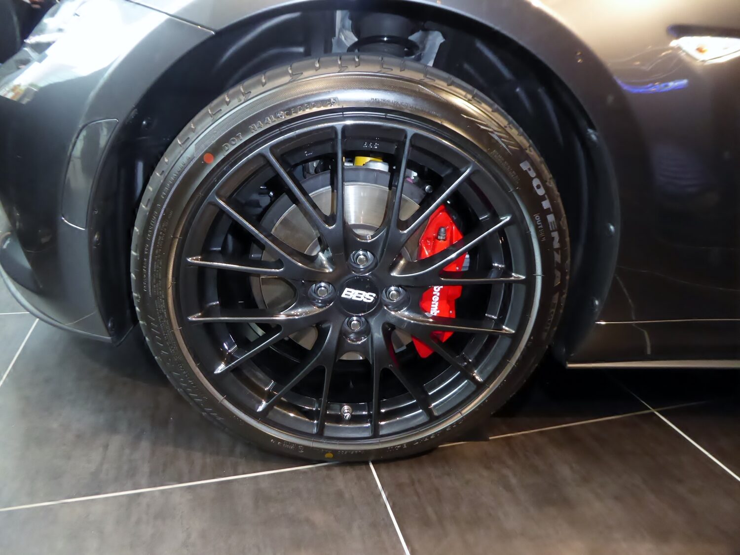 Front wheel of an ND MX-5 with the package: black forged BBS wheel with the BBS center cap and a red Brembo four-piston caliper behind the spokes