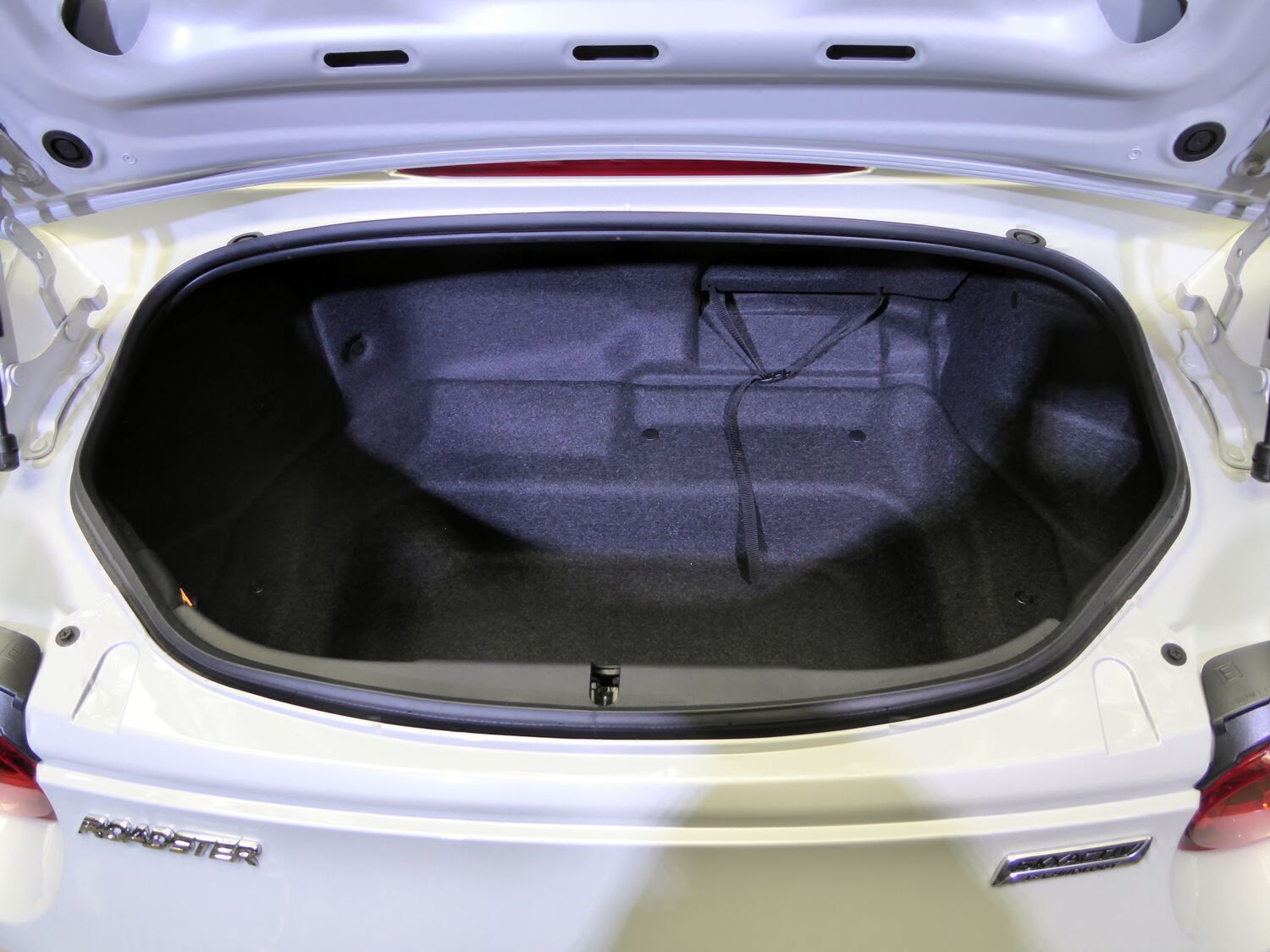 Empty ND Mazda Roadster trunk showing the narrow opening, recessed floor, and side pockets